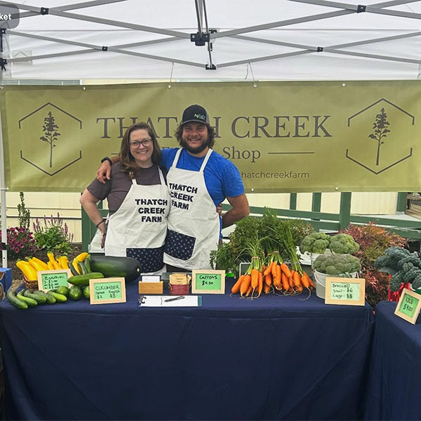 Thatch Creek Farm owners selling their fresh produce.